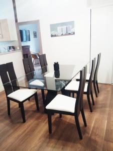 uma mesa de jantar em vidro com cadeiras e uma sala de jantar em Appartement 2 chambres 52 m2 centre ville em Vendôme