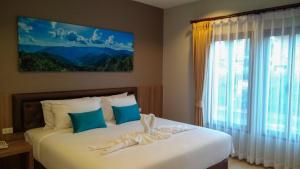 a bedroom with two beds and a large window at Ben Guesthouse in Chiang Rai