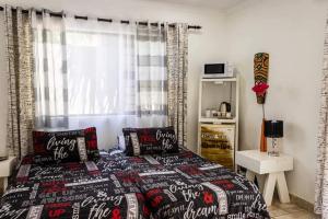 a bedroom with a bed with two pillows on it at MyKhaya-your home away from home in Kempton Park