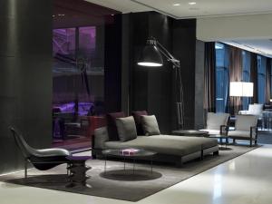 a living room with a couch and a table and chairs at The Met Hotel Thessaloniki, a Member of Design Hotels in Thessaloniki