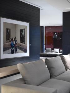 a living room with two beds and a couch at The Met Hotel Thessaloniki, a Member of Design Hotels in Thessaloniki