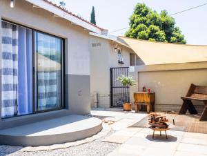 a patio with a large window and a wooden bench at MyKhaya-your home away from home in Kempton Park