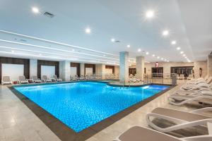 a pool in a hotel with chairs around it at Orange County Belek in Belek