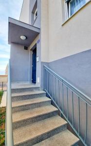 Un escalier mène à un bâtiment avec une porte bleue. dans l'établissement Tusculum apartment Solin, à Solin