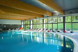ein großer Pool in einem Gebäude mit Fenstern in der Unterkunft Hotel Sport - Terme Krka in Otočec