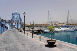 un puerto deportivo con barcos en el agua y un edificio en Perfect flat for your holiday at South Tenerife, en Arona