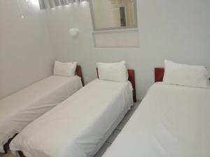 zwei Betten in einem Zimmer mit weißen Laken und Kissen in der Unterkunft Seagull 409 in Margate