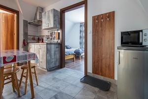 eine Küche mit einem Kühlschrank und einem Tisch mit Stühlen in der Unterkunft Apartamenty Majerczyk in Zakopane