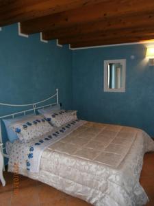 1 cama en un dormitorio con una pared azul en B&B Gigetto, en Pescantina