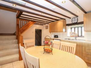 uma cozinha com mesa e cadeiras e um relógio em Waterloo Place Cottage em Norwich