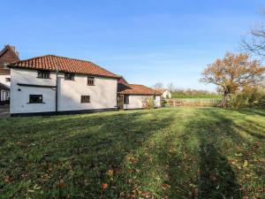 uma casa branca num campo com um quintal em Waterloo Place Cottage em Norwich