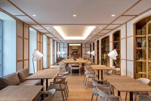 un restaurante con mesas y sillas de madera en Hotel Les Haras en Estrasburgo