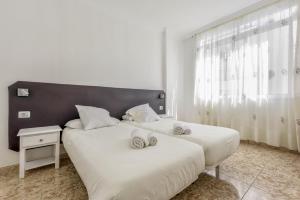 2 łóżka w białym pokoju z oknem w obiekcie Apartamento Albatros w mieście Playa de San Juan