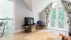 salon z telewizorem z płaskim ekranem obok okna w obiekcie Daintree - Bournemouth w Bournemouth