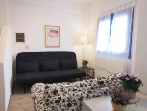 a living room with a couch and a window at Olive Bay Hilltop Apartments Ammouliani in Ammouliani
