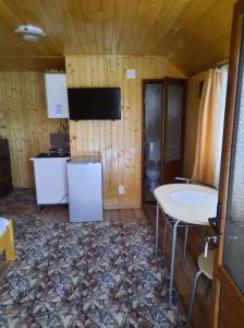 a kitchen with a table and a tv in a room at Casa La LEPE in Roşia Montană