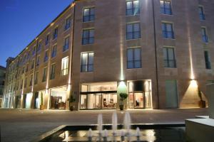 a large building with a fountain in front of it at Gran Hotel Don Manuel in Cáceres