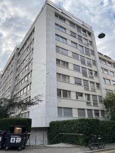 Athénée 40 Residence by Homenhancement في جنيف: مبنى أبيض طويل مع دراجة متوقفة أمامه