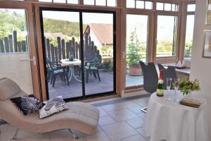 a living room with a table and chairs and a glass door at Ferienwohnung Dittrich in Hilders