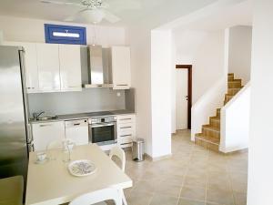 a kitchen with a table and a stove and a staircase at Olive Bay Hilltop Apartments Ammouliani in Ammouliani