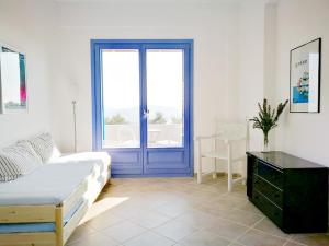 a bedroom with a bed and a blue door at Olive Bay Hilltop Apartments Ammouliani in Ammouliani