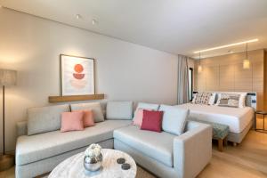 a living room with a couch and a bed at Vathi Cove Luxury Resort & Spa in Chrysi Ammoudia
