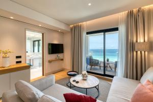 a living room with a view of the ocean at Vathi Cove Luxury Resort & Spa in Chrysi Ammoudia
