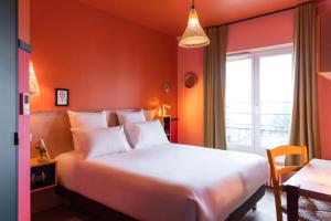 Un dormitorio con una gran cama blanca y una ventana en PAUL & PIA - Welcome Home Hotel en Colmar