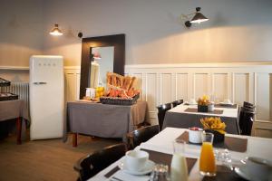 a restaurant with two tables and a refrigerator with food on it at Hotel Les Negociants in Valence