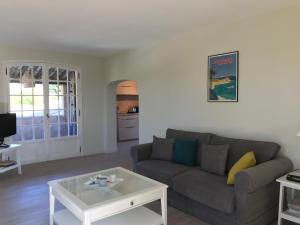 ein Wohnzimmer mit einer Couch und einem Couchtisch in der Unterkunft 06D - Appartement spacieux avec terrasses, jardin et piscine in Roquefort-les-Pins