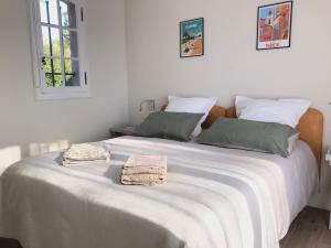 ein Schlafzimmer mit einem großen weißen Bett mit zwei Handtüchern darauf in der Unterkunft 06D - Appartement spacieux avec terrasses, jardin et piscine in Roquefort-les-Pins