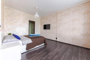 a bedroom with a bed and a tv on a wall at Apartment Hanaka Skryabina 8 in Moscow