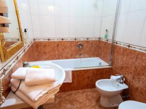 ein Badezimmer mit einer Badewanne, einem WC und einem Waschbecken in der Unterkunft Alla Basilica Rooms in Rom