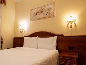 ローマにあるアラ バシリカ ルームスのベッドルーム1室(ベッド1台、壁に照明2つ付)