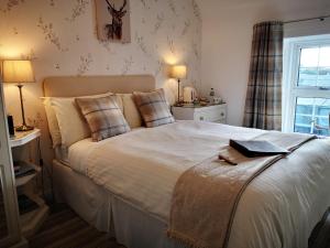 Un dormitorio con una gran cama blanca y una ventana en Lossiemouth House, en Lossiemouth