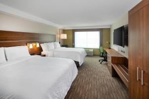 EnfieldにあるHoliday Inn Express & Suites Halifax Airport, an IHG Hotelのベッド2台、薄型テレビが備わるホテルルームです。