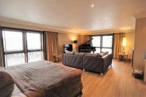 1 dormitorio con cama, sofá y piano en The Mansefield Hotel, en Elgin