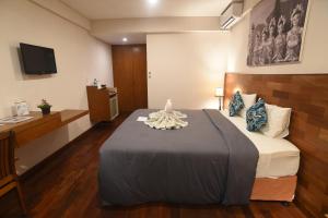 Habitación de hotel con cama y escritorio en PNB Beach Resort, en Canggu