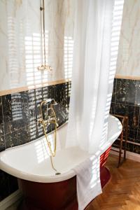 a bath tub with a shower curtain in a bathroom at St Giles House Hotel in Norwich