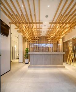 an office lobby with a reception desk and wooden ceiling at Cool Living in Jakarta