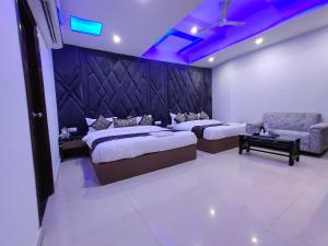 a hotel room with two beds and a couch at Hotel 51 in Amritsar