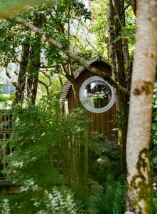 a clock in the middle of a forest at RiverBeds - Luxury Wee Lodges with Hot Tubs in Glencoe