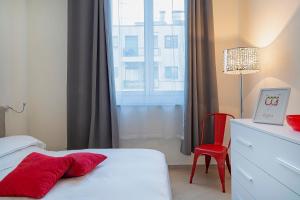 - une chambre avec un lit, une chaise rouge et une fenêtre dans l'établissement Casa Vermiglio al porto di Genova by Wonderful Italy, à Gênes