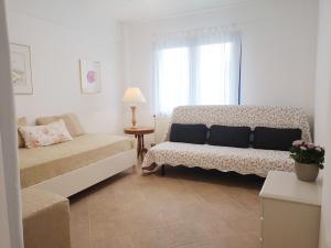a living room with a couch and a window at Olive Bay Hilltop Apartments Ammouliani in Ammouliani