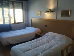 a hotel room with two beds and a window at Hostal agripino y Restaurante asiático in Mora