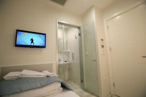 baño con TV en la pared y cama en Ravvda Hotel en Estambul