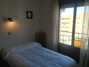 een slaapkamer met een bed en een groot raam bij Hostal agripino y Restaurante asiático in Mora