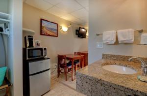 a bathroom with a sink and a microwave at Atlantic Oceanfront Hotel, Wells Beach in Wells