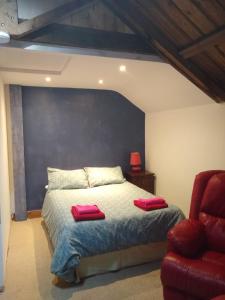 a bedroom with a bed with two red pillows on it at Watercress Barns in Sittingbourne