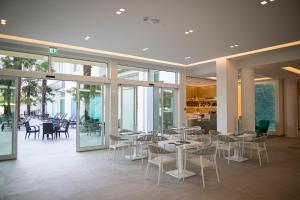 a restaurant with tables and chairs and windows at Hotel Terme Venezia in Abano Terme